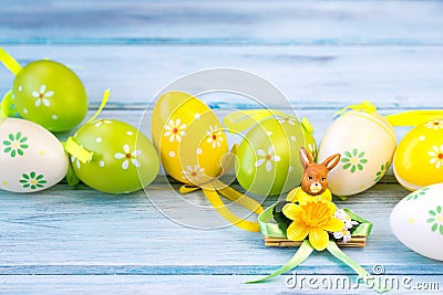Colorful Easter eggs and rabbit statuette on a wooden background Stock Photo