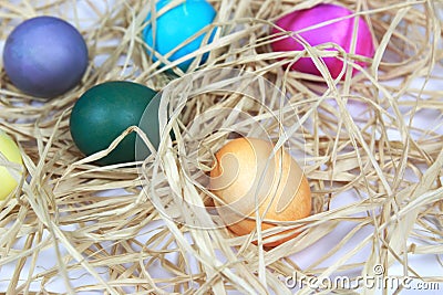 Colorful easter eggs in raffia nest on white background Stock Photo