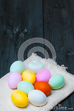 Colorful Easter eggs on towel on old rustic wooden background Stock Photo