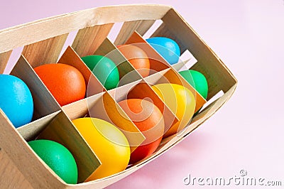 Colorful Easter eggs in a wicker basket. Pink background. Easter holiday concept Stock Photo