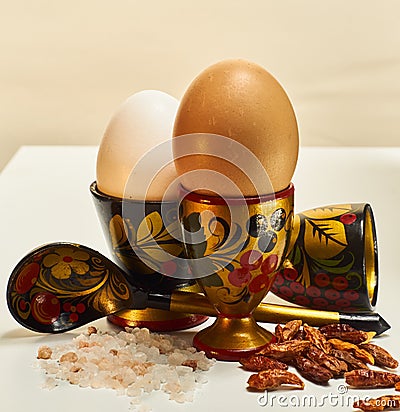 Colorful eggcups with eggs, spoon, salt and chili Stock Photo