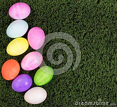 Colorful eggs for Easter holiday forming left hand border on green grass Stock Photo