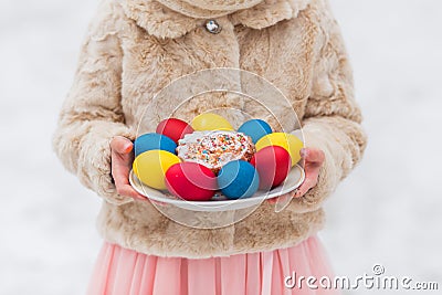 Colorful eggs for Easter holiday in hands on a plate close up Stock Photo