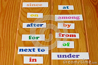 Colorful English preposition cards on wooden table Stock Photo