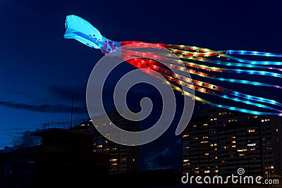 Colorful enlightened large kite with funny face and octopus arms over Bremerhaven Editorial Stock Photo