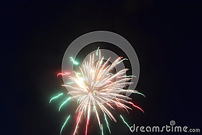 Colorful explosion in the night sky on 4th of July green red and white fireworks bright burst of light Stock Photo