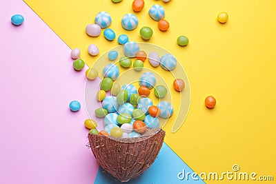 Colorful explosion of sweets in a coconut on bright multi-colored backgrounds, creative still life Stock Photo