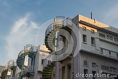 Colorful exterior spiral staircases against blue sky, Singapore Stock Photo