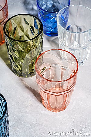 Colorful faceted and geometric drink glass, group of empty green, red, blue and transparent drinkware Stock Photo