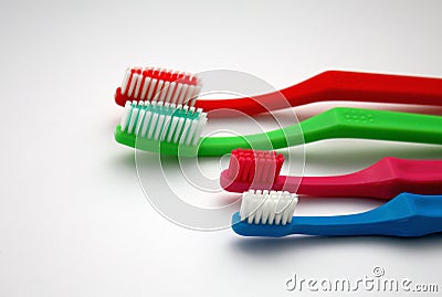 Colorful family toothbrushes on white background, red and green adult toothbrushes and pink and blue little two for children Stock Photo