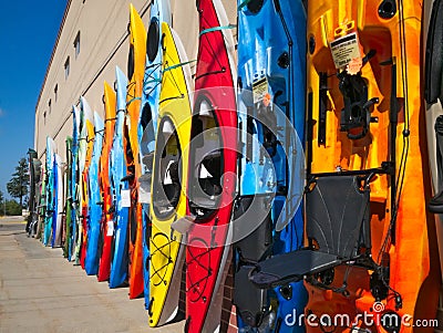 Colorful fiberglass kayaks on display outside sporting goods store Stock Photo