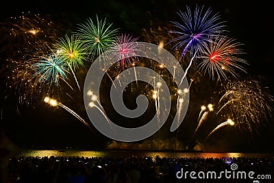 Colorful fireworks celebration and the night sky background with crowded people on the beach Stock Photo