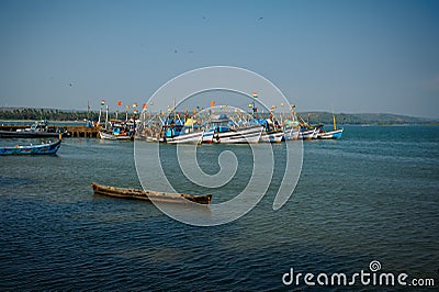 Colorful fishing boats with blue and white hulls and Indian flags on the masts, on the fishing pier in Goa. Wooden boats Stock Photo