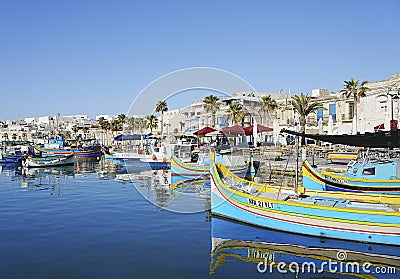 Colorful fishing boats in port of european Marsaxlokk town in Malta Stock Photo