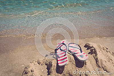 Colorful flipflop pair on sea beach. Concept of vacantion. Stock Photo