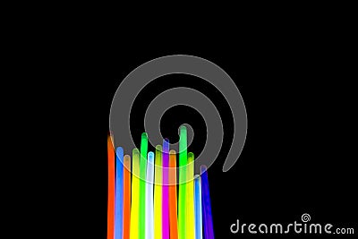 Colorful fluorescent light neon big glow stick on mirror reflection black background Stock Photo