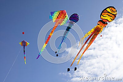 Colorful flying kites against a blue sky Stock Photo