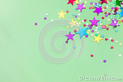 Colorful foil stars confetti sparse on trendy mint colored backg Stock Photo