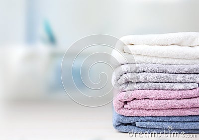 Colorful folded towels stack on table empty space. Stock Photo