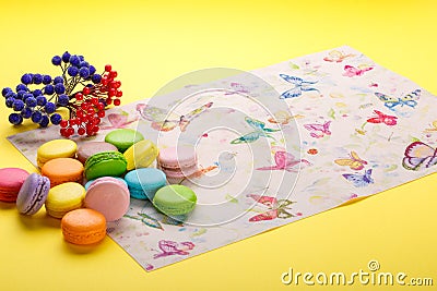 Colorful French macaroons cookies on the napkin over yellow background Stock Photo