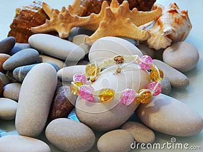 Colorful friendship bracelet on sea pebble Stock Photo