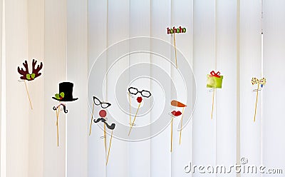 Colorful funny hats, horns and glasses dance on the blinds Stock Photo