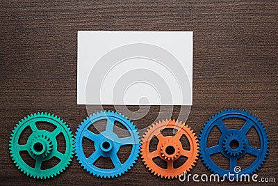 Colorful gears on the brown wooden background Stock Photo