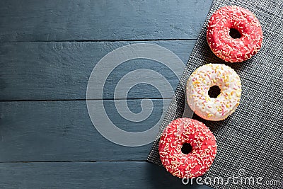 Colorful glazed donuts on dark wooden background. Stock Photo