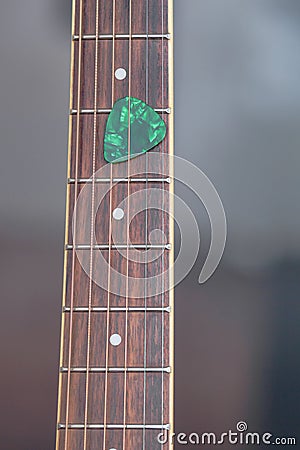 Colorful guitar pick on finger board Stock Photo