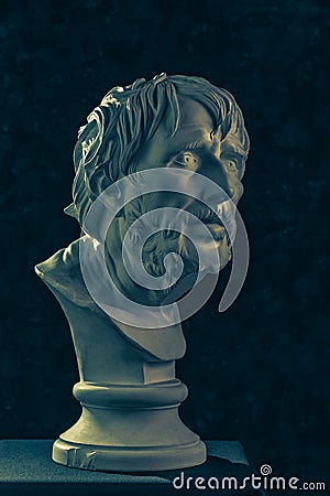 Colorful gypsum copy of ancient statue of Lucius Seneca head for artists on a dark textured background. Seneca 4 BC-65 AD Roman Editorial Stock Photo