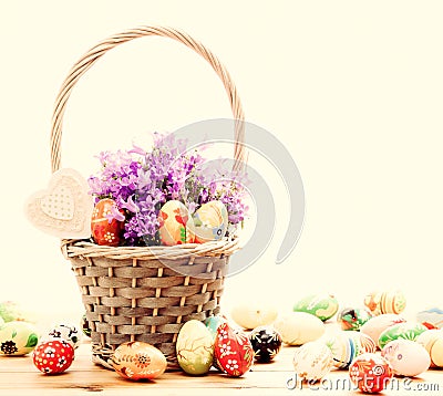 Colorful hand painted Easter eggs in basket and on wood. Handmade vintage decoration Stock Photo