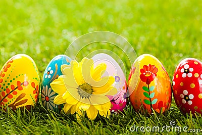 Colorful hand painted Easter eggs and spring flowers in grass Stock Photo