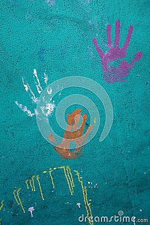 Colorful handprints on a cement wall Stock Photo