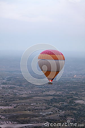 Colorful Hot Air Balloon Flying In Foggy Sky Above Fields Stock Photo