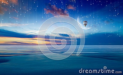 Colorful hot air balloon in sunrise sky with crescent above sea Stock Photo