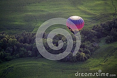 A colorful hot air balloons flies above the Iowa countryside. Editorial Stock Photo