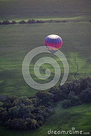 A colorful hot air balloons flies above the Iowa countryside. Editorial Stock Photo