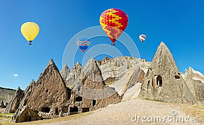 Colorful hot air balloons flying over volcanic cliffs at Cappadocia Stock Photo