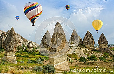 Colorful hot air balloons flying over volcanic cliffs at Cappadocia Stock Photo