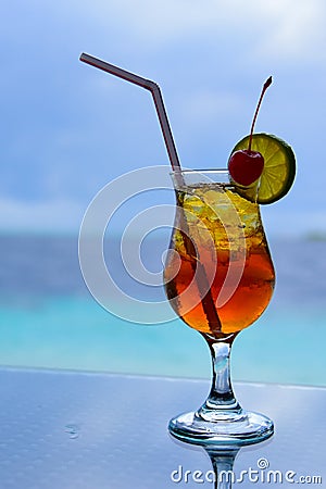 Colorful juice beverage against blue sea Stock Photo