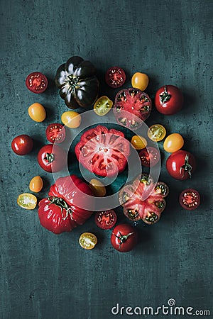 Colorful juicy tomatoes on green table, top view. Stock Photo