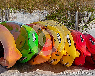 Colorful kayaks on the beach awaiting rental by active people or vacationers Editorial Stock Photo