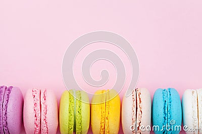 Colorful macaron or macaroon on pink pastel background top view. Flat lay composition. Stock Photo