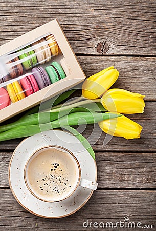 Colorful macaroons, coffee cup and yellow tulips Stock Photo