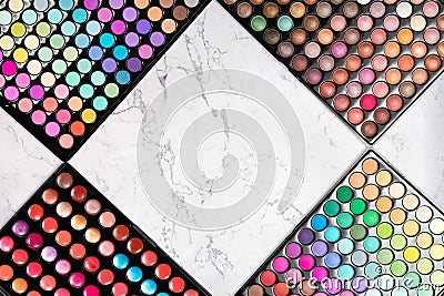 Colorful make-up eyeshadow palettes on white marble background. Rhombus shape frame Stock Photo