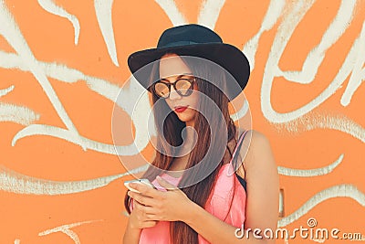 A colorful millennial girl messaging from her mobile phone Stock Photo