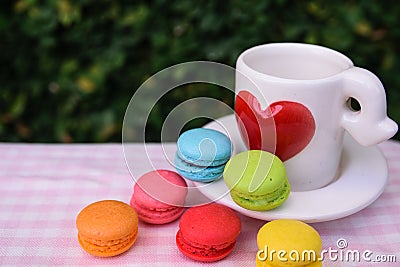 Colorful mini macarons with love mug Stock Photo