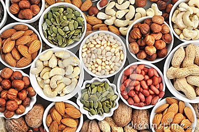Colorful mix of nut and seed varieties: peanut, cashew, hazelnut, almond, pine nuts, walnut, pumpkin seeds; healthy diet snack Stock Photo