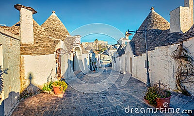 Colorful morning view of strret with trullo trulli - traditional Apulian dry stone hut with a conical roof. Nice spring citysca Stock Photo