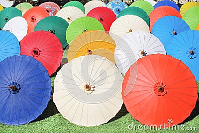 Colorful multicolored paper umbrella group on grass floor, decoration for background Stock Photo